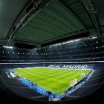 Vnútorný pohľad na štadión Santiaga Bernabeua s nápadne zobrazeným nápisom „REAL MADRID“.