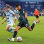 22. júla 2026; Kansas City, Kansas, USA; Stredopoliar klubu Minnesota United FC Joaquín Pereyra (26) vyráža na bránu, keď stredopoliar Sporting Kansas City Jake Davis (8) bráni počas prvého polčasu zápasu v detskom Mercy Parku. Povinný kredit: Denny Medley-Imagn Images