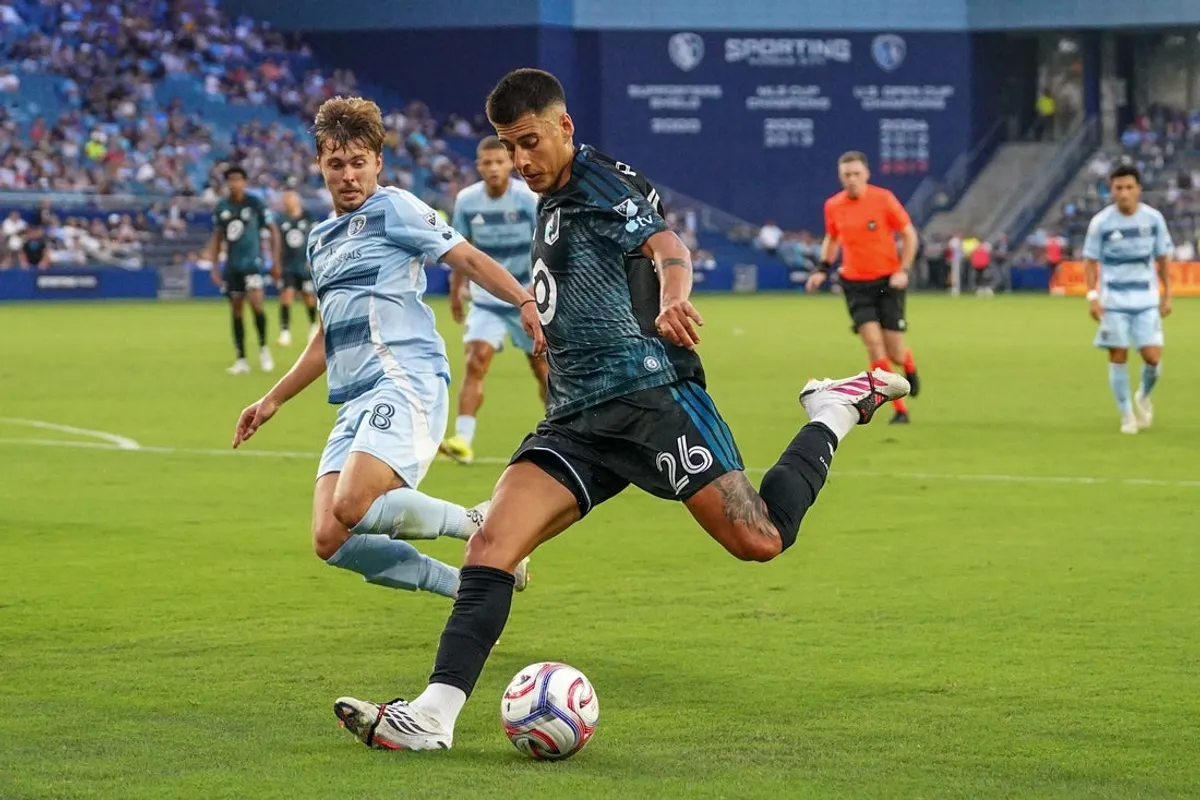 22. júla 2026; Kansas City, Kansas, USA; Stredopoliar klubu Minnesota United FC Joaquín Pereyra (26) vyráža na bránu, keď stredopoliar Sporting Kansas City Jake Davis (8) bráni počas prvého polčasu zápasu v detskom Mercy Parku. Povinný kredit: Denny Medley-Imagn Images