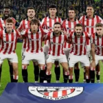 Futbalový tím Athletic Bilbao pózuje na fotografii so svojím logom v popredí.